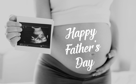 Pregnant woman holding ultrasound photo. Fathers day.