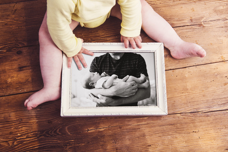 Unrecognizable baby holding picture frame. Fathers day.の写真素材