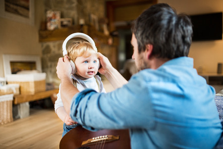 Father and son with smartphone and earphones, listening music.の写真素材