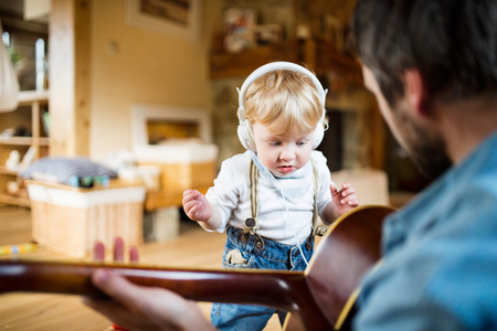 Father and son with smartphone and earphones, listening music.の写真素材