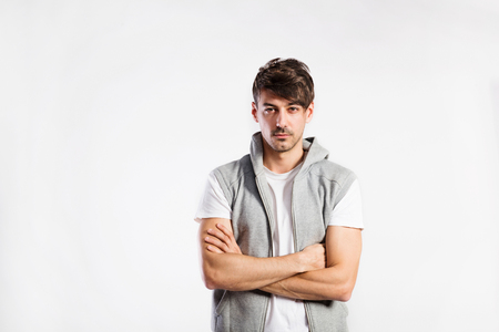 Handsome fitness man in vest with hood, studio shot.の写真素材