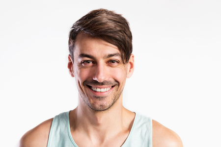 Handsome fitness man in blue tank top shirt, studio shot.の写真素材
