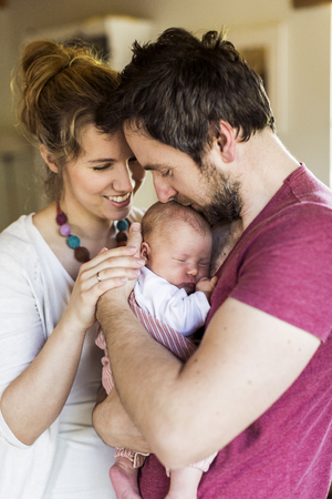 Beautiful young parents holding their cute baby daughterの写真素材