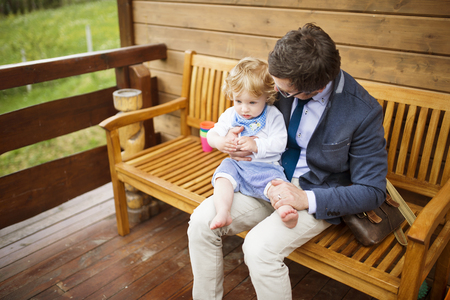 Businessman with little son sitting on front porch.の写真素材