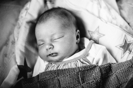 Close up of beautiful newborn baby daughter lying on bedの写真素材
