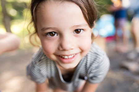 Cute little girl outdoors in nature camping with her family.の写真素材