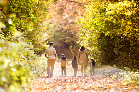 Beautiful young family on a walk in autumn forest.の写真素材