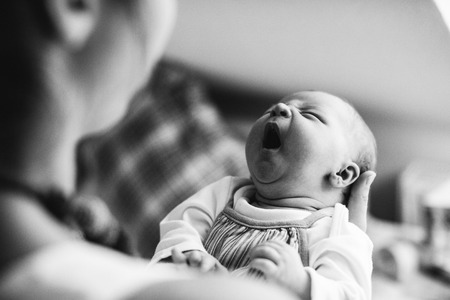 Unrecognizable mother holding crying newborn baby girl.の写真素材