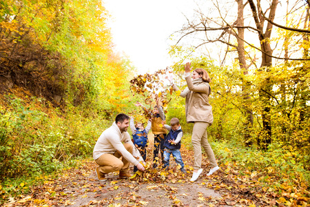 Beautiful young family on a walk in autumn forest.の写真素材
