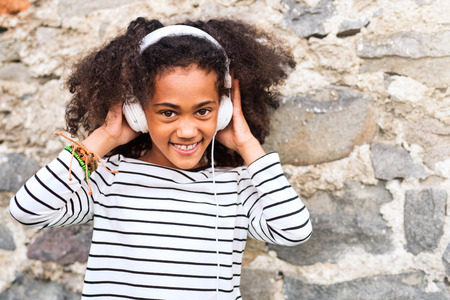 Beautiful african american girl with headphones, listening music