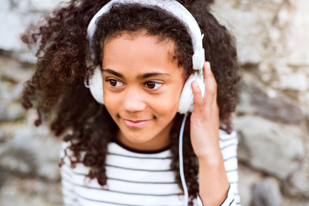 Beautiful african american girl with headphones, listening musicの写真素材