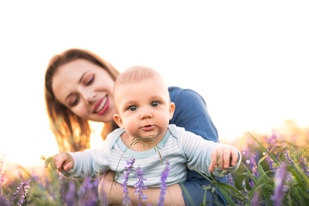 Young mother in nature with baby son in the arms.の写真素材