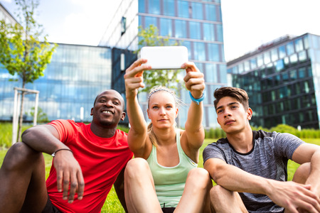 Young runners in the city taking selfie witn smart phone.