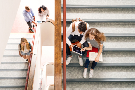 Teenage students on stairs in high school.の写真素材