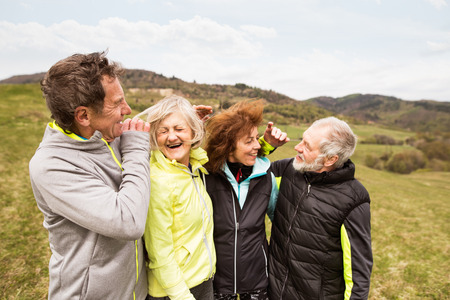Group of senior runners outdoors, resting and hugging.の写真素材