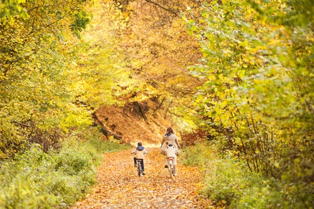 Mother with little sons cycling in autumn park.の写真素材