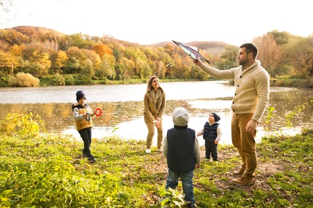 Beautiful young family on a walk in autumn forest.の写真素材