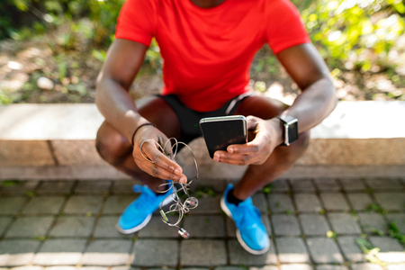Unrecognizable runner with smart phone, listening music.の写真素材