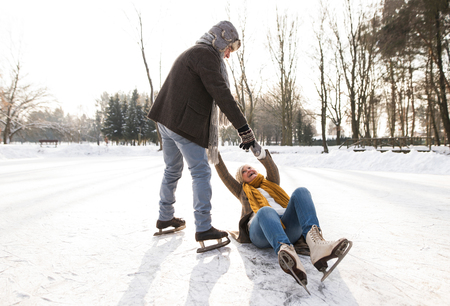 Senior couple in sunny winter nature ice skating.の写真素材