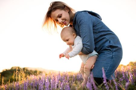 Young mother in nature with baby son in the arms.の写真素材