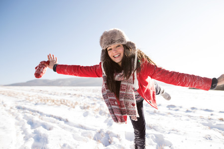 Beautiful young woman, having fun in the snow.の写真素材