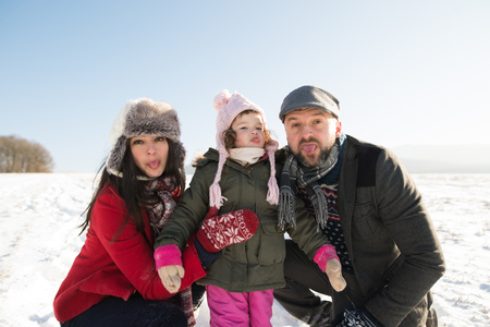 Father and mother with their daughter, winter day.の写真素材