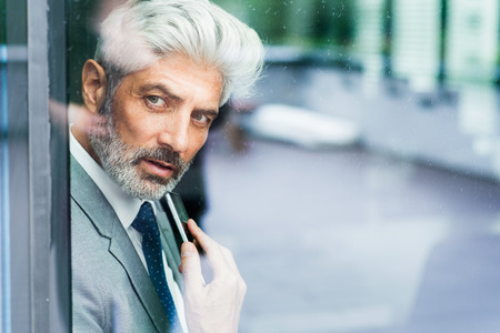 Mature businessman in the office looking out.の写真素材