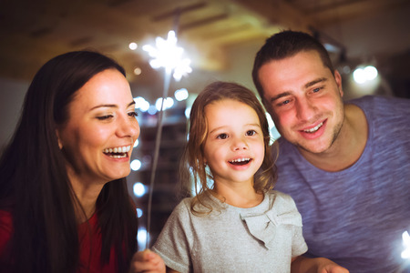 Young family with sparklers at Christmas time at home.の写真素材