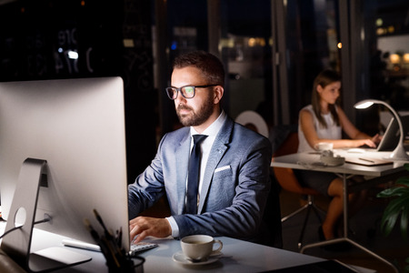 Businessman in his office at night working late.の写真素材