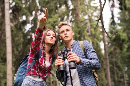 Teenage couple hiking in forest. Summer vacation.
