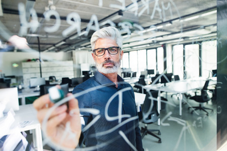 Mature businessman with gray hair in the office.の写真素材