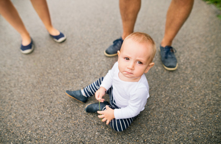 Little boy sitting on the pavement in nature.の写真素材
