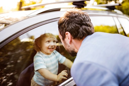 Little boy in the car, looking out of window at his father.の写真素材