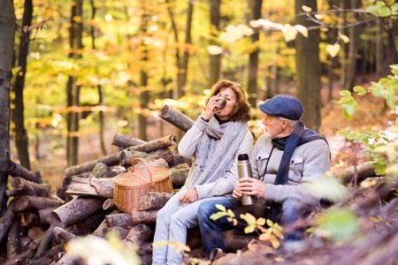 Senior couple on a walk in autumn forest.の写真素材