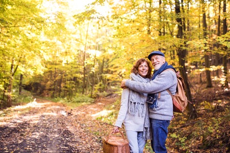 Senior couple on a walk in autumn forest.の写真素材