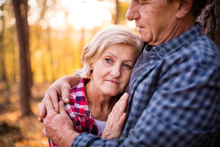 Senior couple on a walk in an autumn forest.