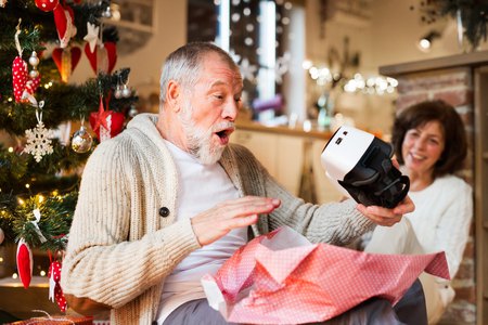 Senior couple in front of Christmas tree with VR goggles.の写真素材