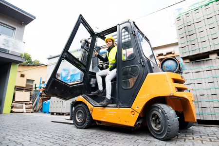 Female forklift truck driver outside a warehouse.の写真素材