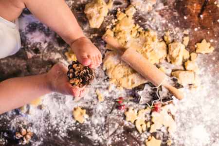 Young family making gingerbread cookies at home.