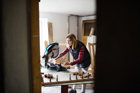 Young woman worker in the carpenter workroom.