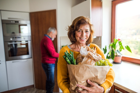 Senior couple preparing food in the kitchen.の写真素材