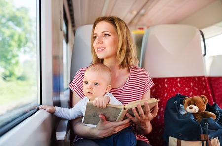 Young mother travelling with baby by train.の写真素材