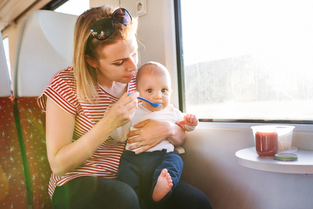 Young mother travelling with baby by train.の写真素材