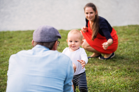 Little boy with parents making first steps.の写真素材