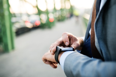 Mature businessman with a smartwatch in a city.
