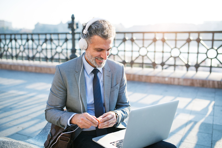 Mature businessman with a laptop in a city.の写真素材