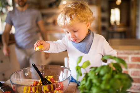 Young father with a toddler boy cooking.の写真素材