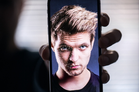 A smartphone using face ID recognition system.