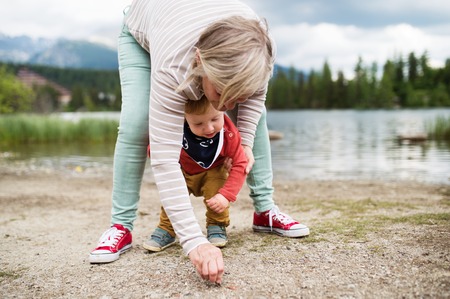 Senior woman with little boy at the lake, summer day.の写真素材