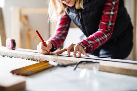 Young woman worker in the carpenter workroom.の写真素材